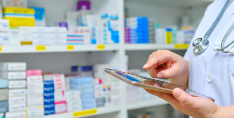 Doctor using computer tablet for search bar on display in pharmacy
