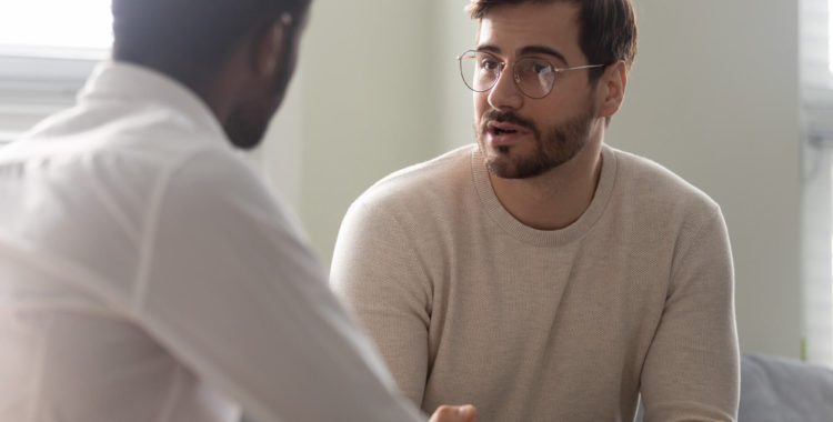 African counsellor sitting in front of patient listens his complaints