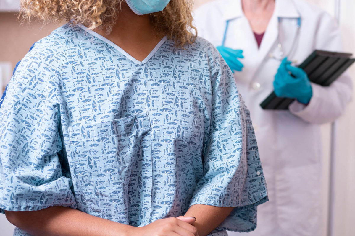 Young African American Woman prepares for breast exam, mammogram at doctor’s office or hospital.