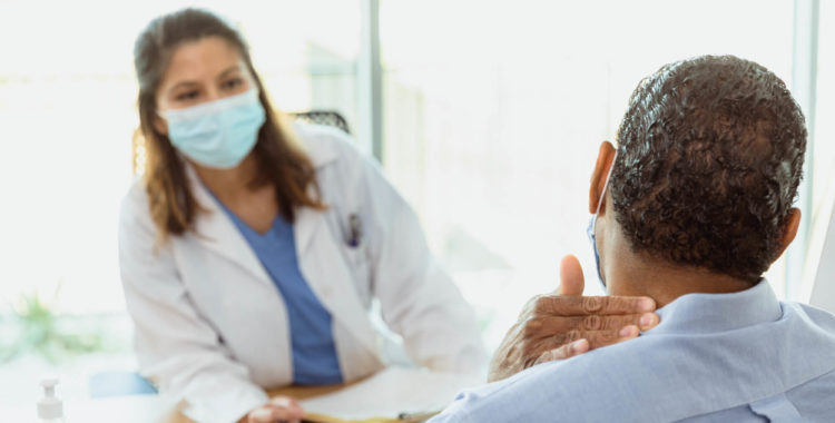 Man discusses neck pain with doctor