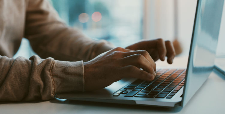 Shot of an unrecognizable businessman working on his laptop in the office