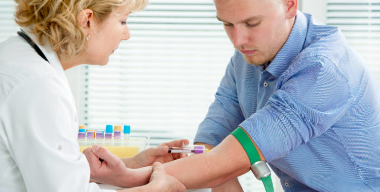 Nurse taking blood sample from patient at the doctors office.