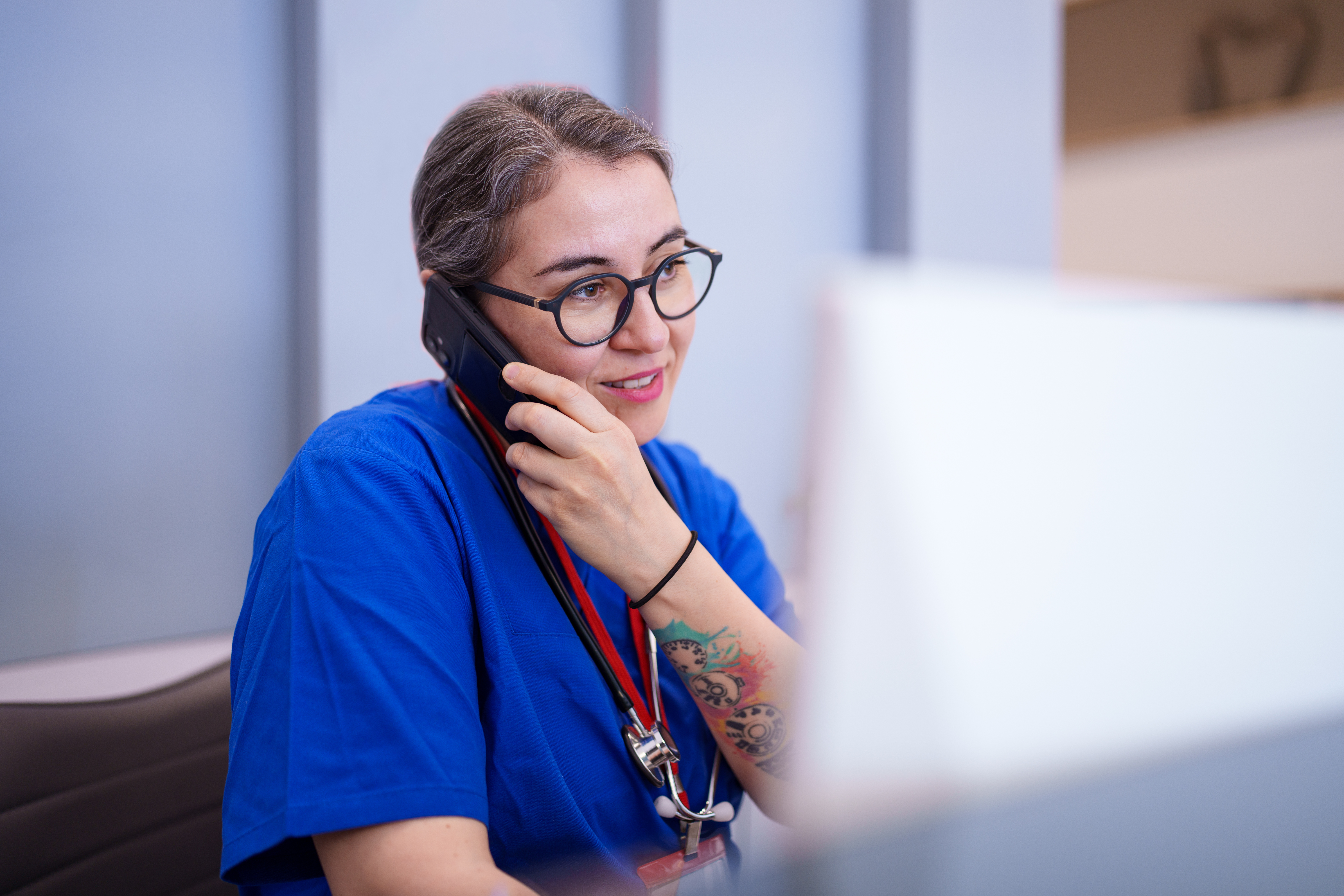 Healthcare Professional Talking on the Phone at Desk