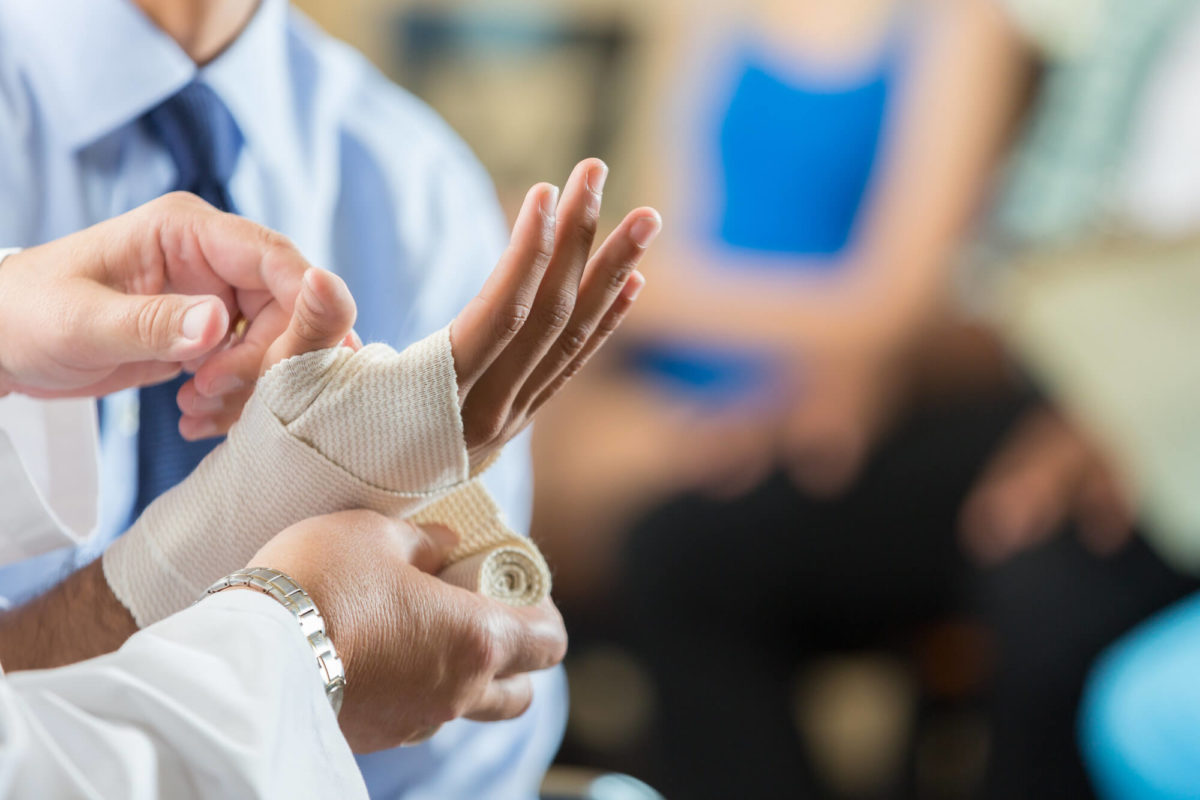 Patient having wrist bandaged by nurse in hospital triage center