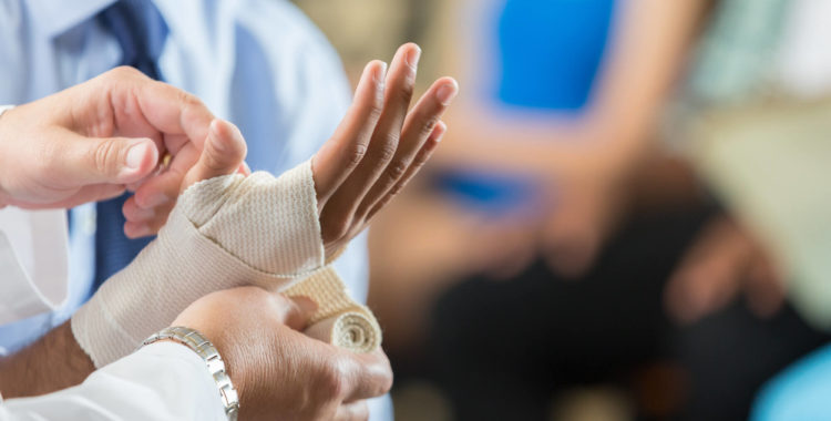 Patient having wrist bandaged by nurse in hospital triage center