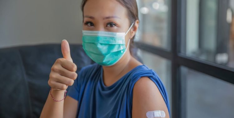 A girl with her thumb up after getting a shot