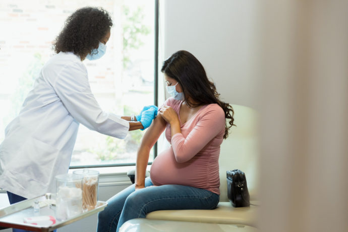 Pregnant woman receives vaccine at doctor’s office