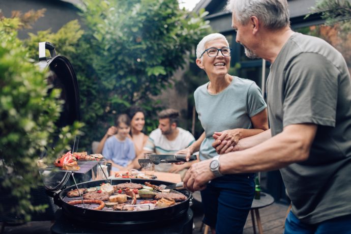 Happy senior couple enjoying making barbecue for their family