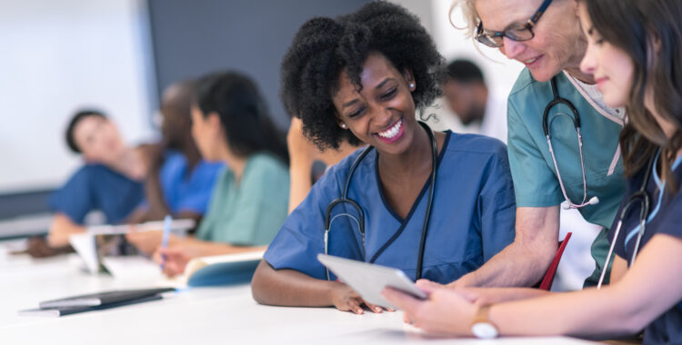 Senior female lecturer assists medical students during class