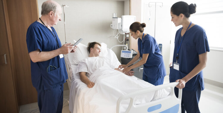 Medical team treating male patient in hospital bed