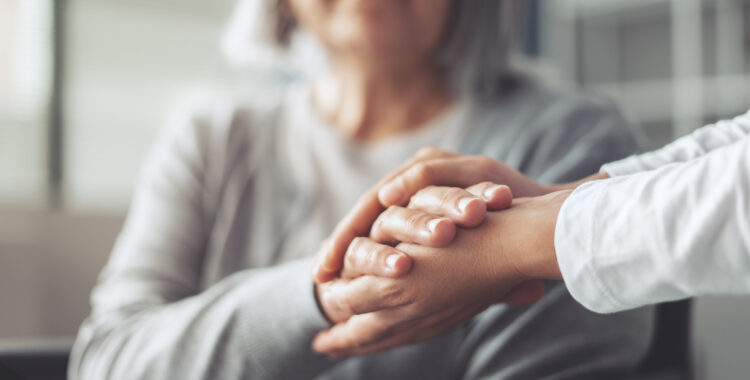 Hands holding old woman’s hands