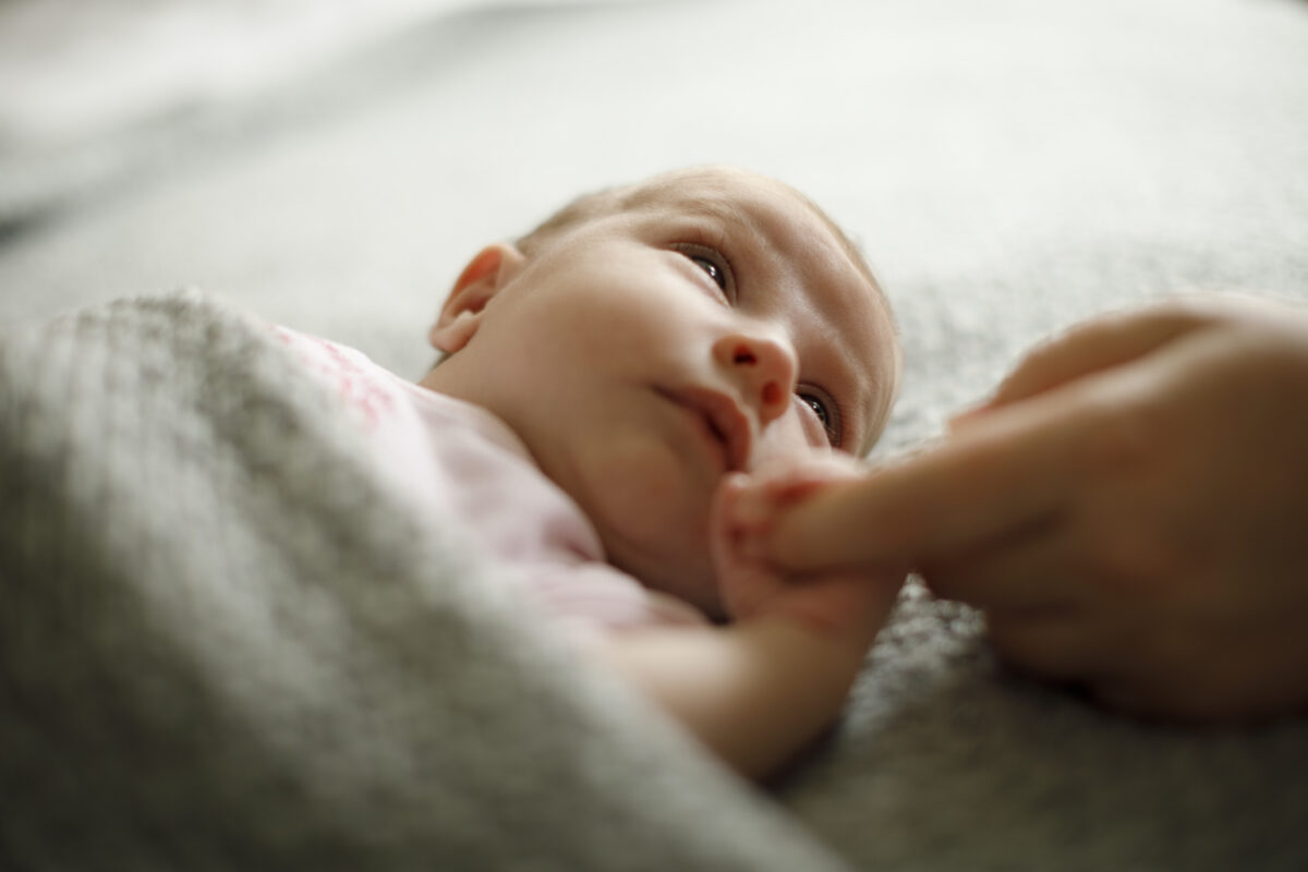 Newborn baby holding mother’s hand