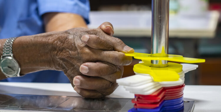 Occupational therapy: hand function training in a stroke patient by using single curve metal pipe and pinto improve their hand rehabilitation at a therapy room in the hospital.