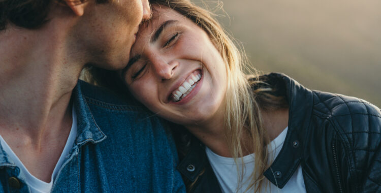 Romantic boyfriend kissing on happy girlfriend’s forehead
