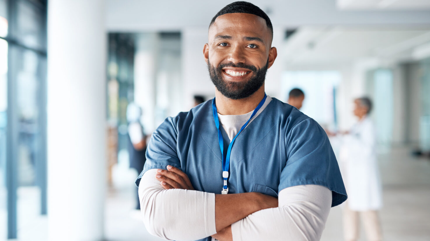 Nurse, hospital employee and portrait of black man in a healthcare, wellness and clinic feeling proud. Happy, smile and doctor in a medical facility with happiness from workplace vision and success