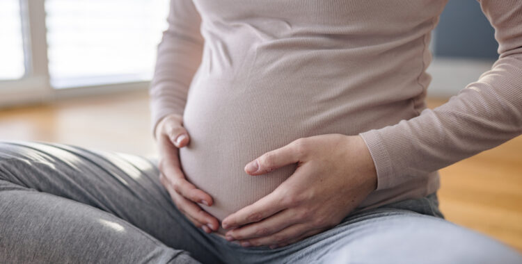 Close Up Shot Of A Pregnant Woman Holding Her Belly