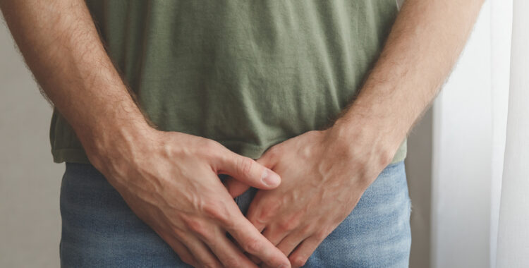 Man cover his groin by hands. Men’s health. Urology problems male