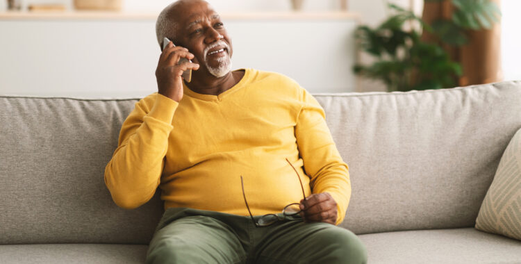 Senior African American Man Talking On Cellphone Sitting At Home
