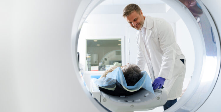 Doctor and female patient in the room of computed tomography at hospital. Healthcare concept