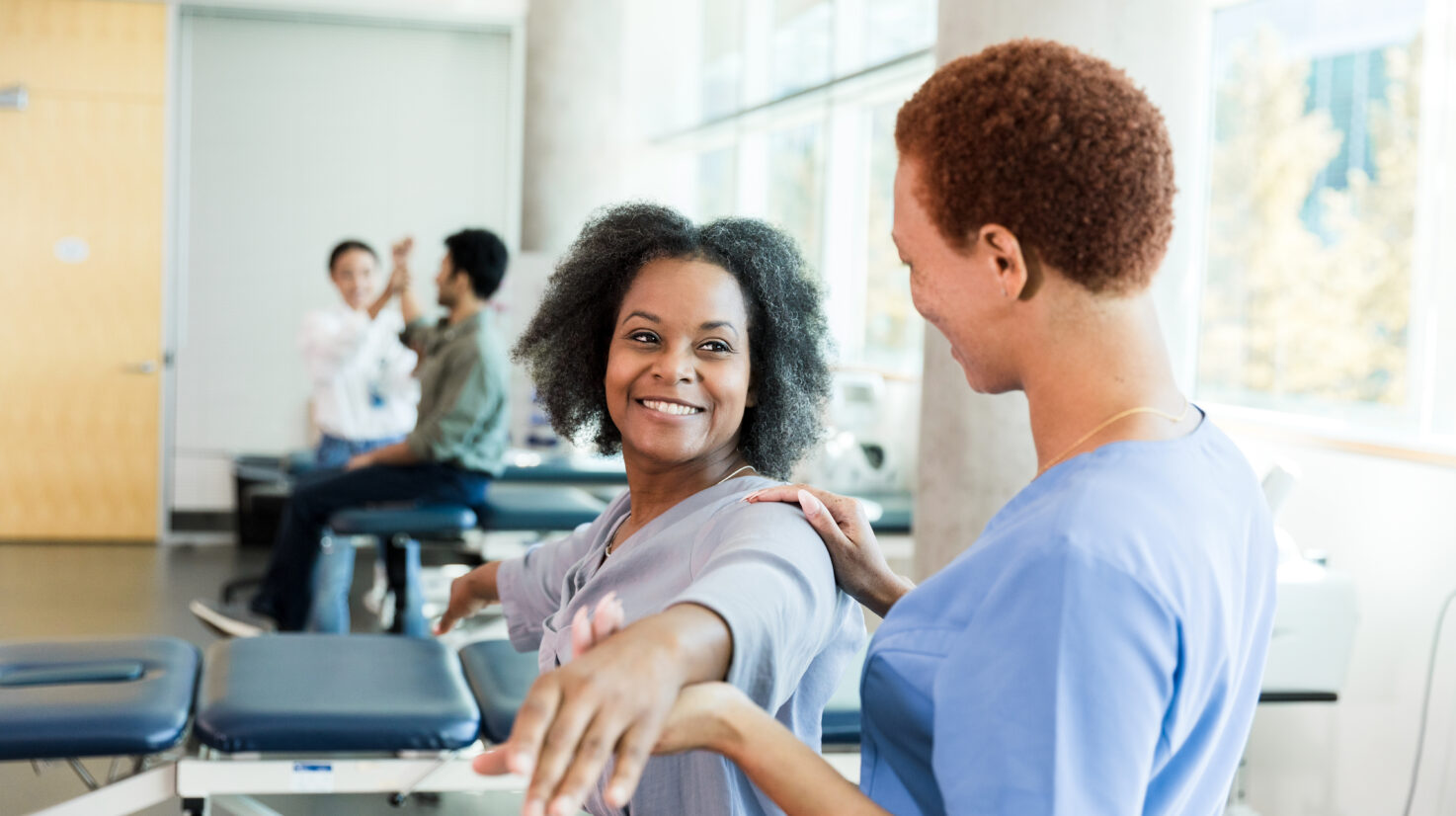 Physical Therapist Assisting Patient with Arm Exercises
