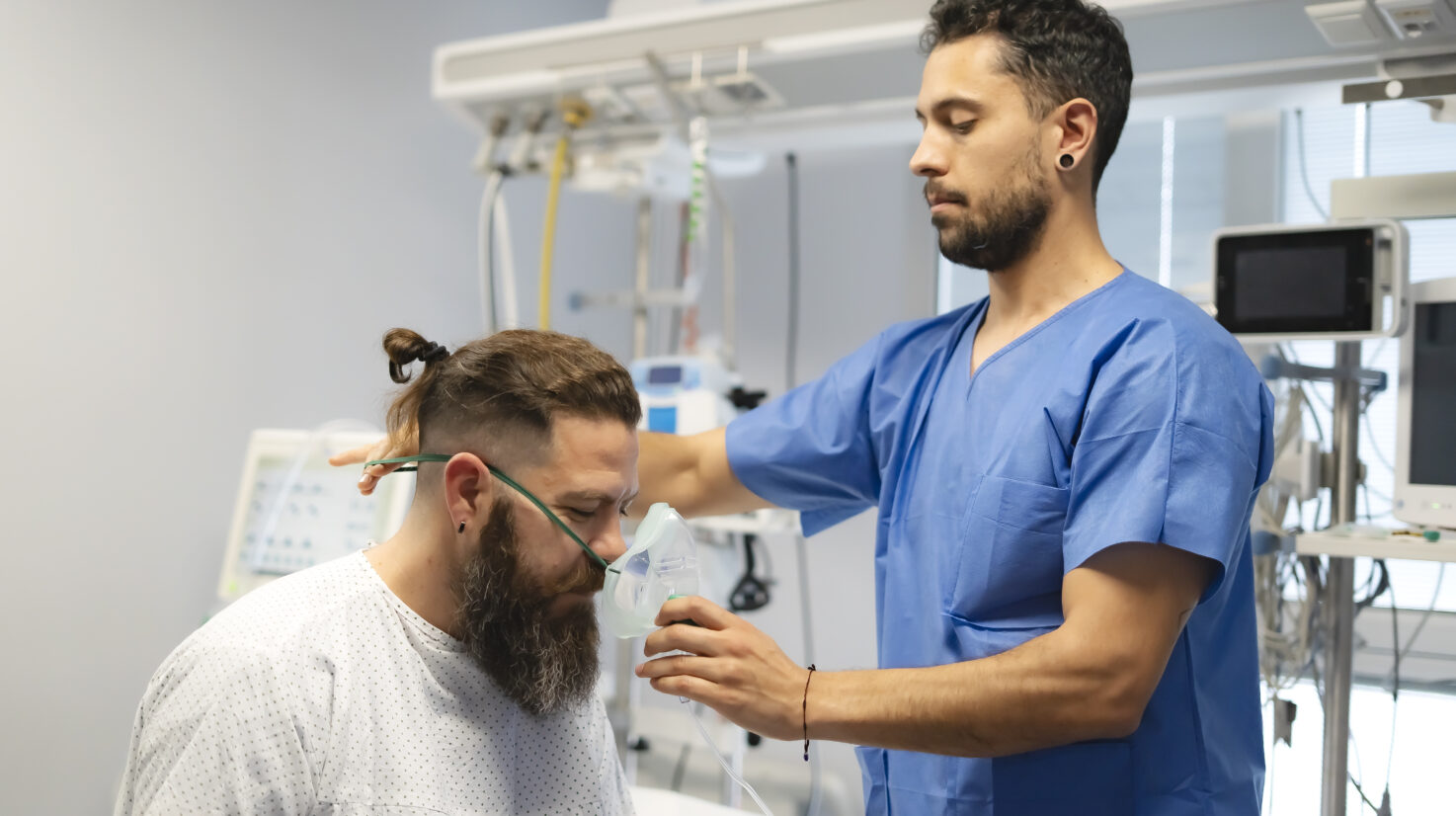 Doctor placing oxygen mask on patient in hospital room