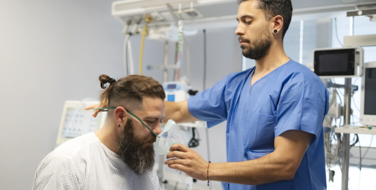 Doctor placing oxygen mask on patient in hospital room