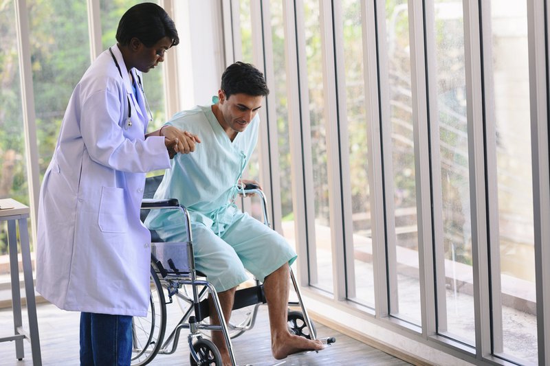 Male patient in wheelchair receiving stroke treatment