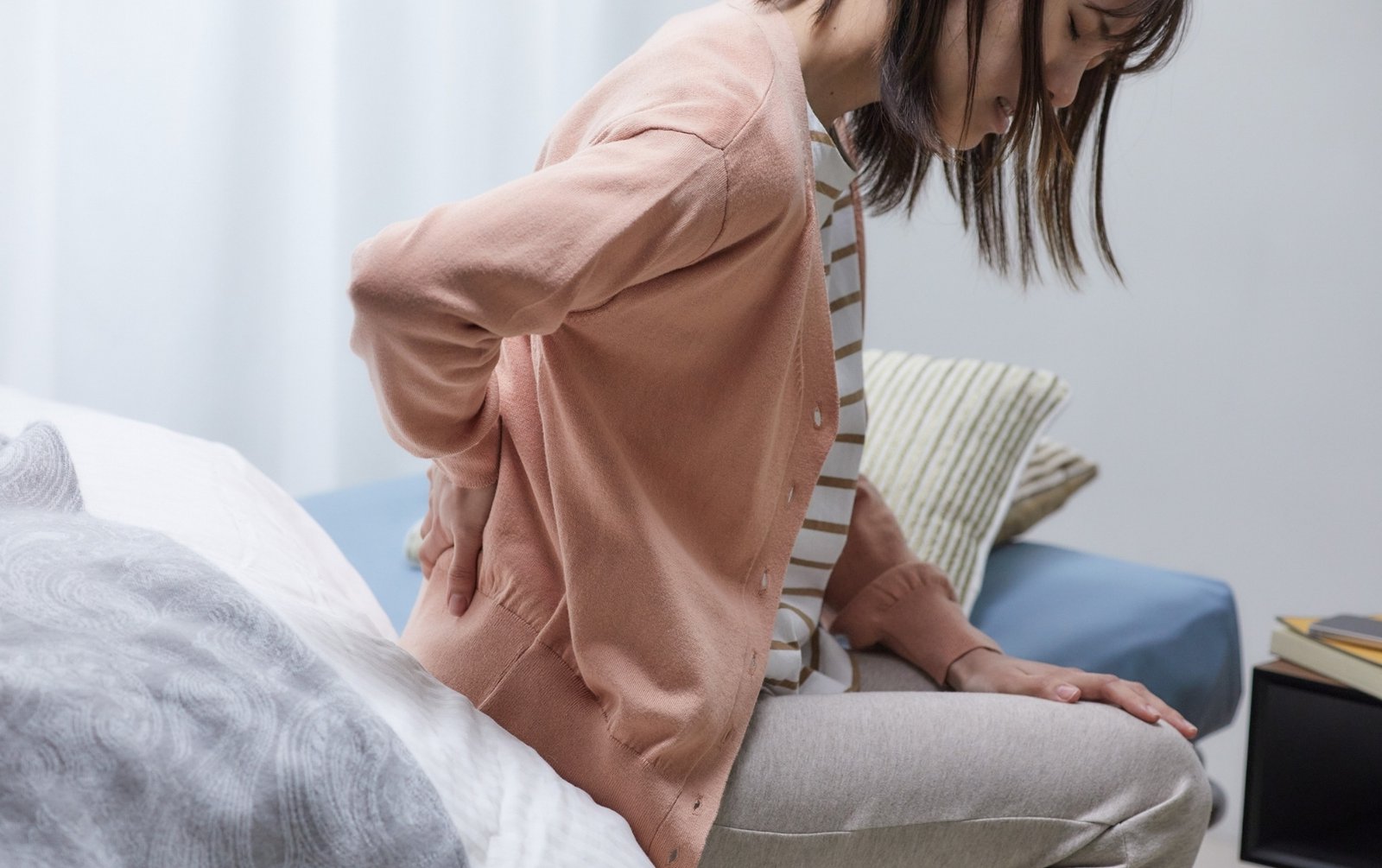 Woman with an aching lower back, a sign of poor bone health in women
