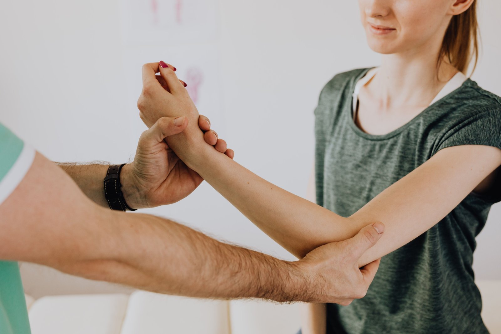 Young woman with elbow joint pain with a physical therapist