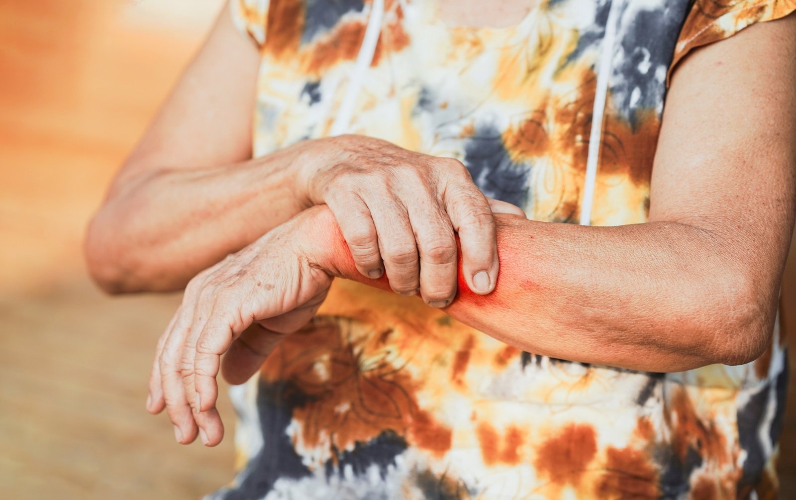 Elderly woman holding her arm, managing arthritis pain