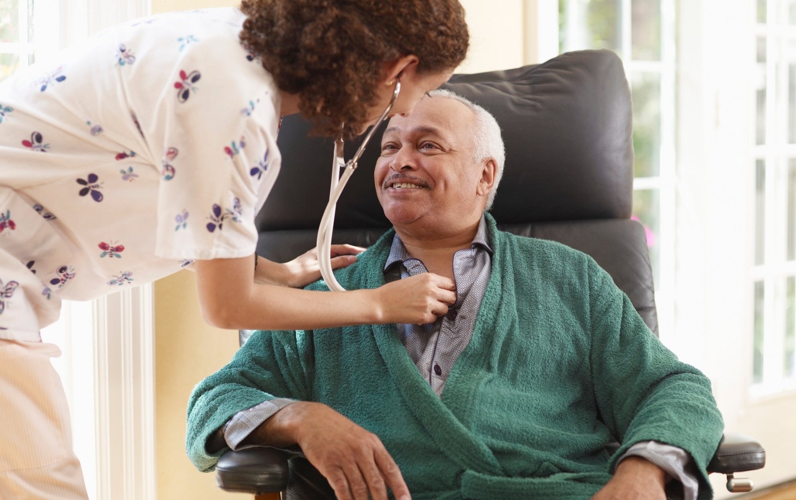 Elderly man receiving care from home health nurse