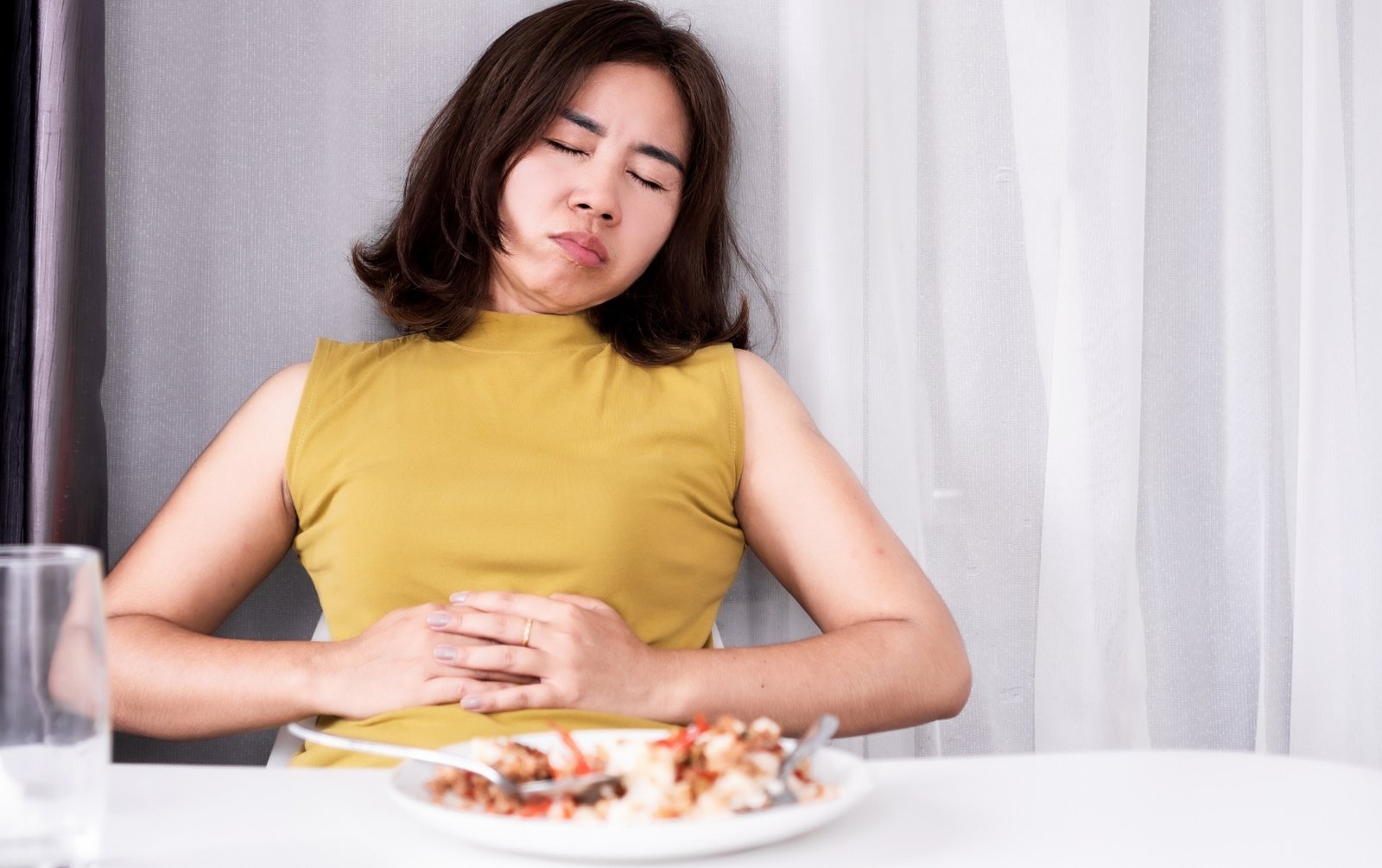 Woman feeling full after a meal, what causes bloating in women